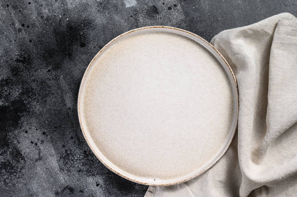 istock White empty round plate, restaurant background. Black background. Top view. Copy space. 1225825221