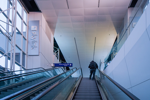 A passenger is riding the escalator in Sydney Airport, Australia.