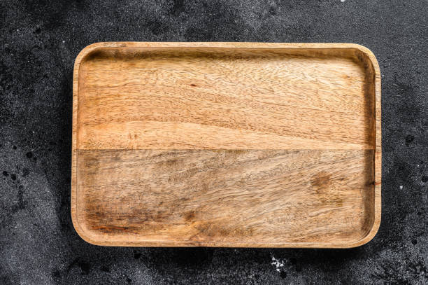 istock Wooden antique tray. Black texturized background. Top view. Copy space 1225825560