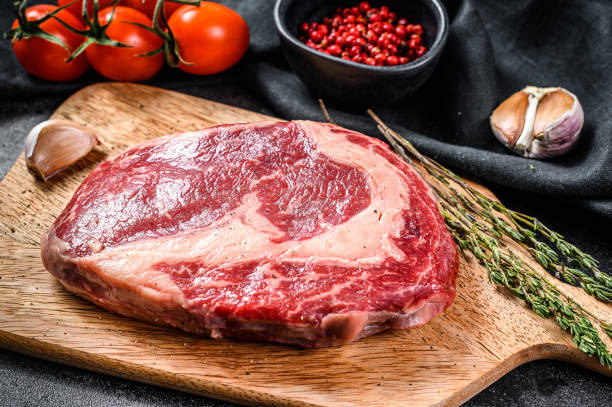 istock Marbled beef fillet steak on cutting Board. black background. top view 1225826531