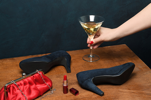 Female hand with glass of cocktail and accessories