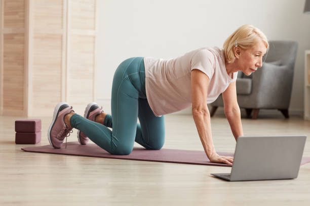 istock Senior woman exercising on the floor 1225828047