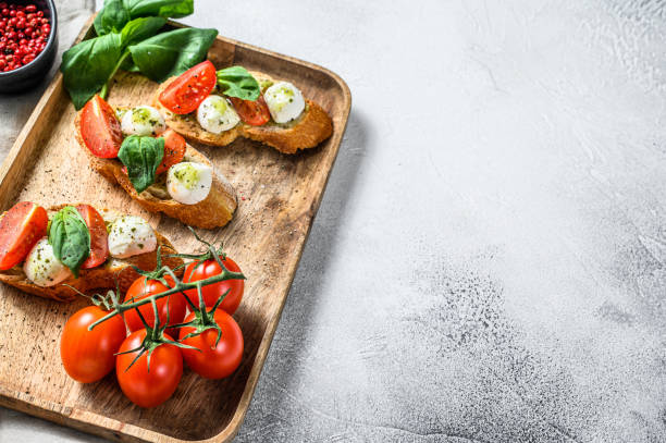 istock sandwiches with tomatoes, mozzarella cheese and basil. italian appetizer, antipasto. gray background. top view. Copy space 1225829939