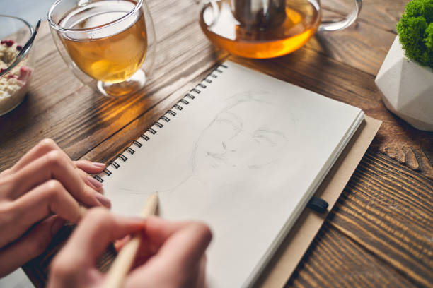 istock Female artist drawing sketch in notebook at home 1225829986