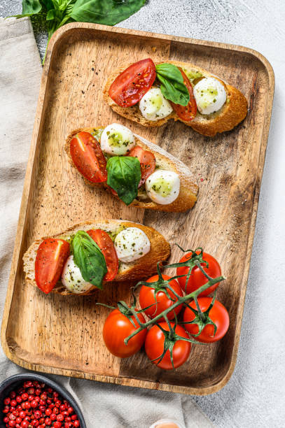 istock Bruschetta with tomatoes, mozzarella cheese and basil. italian appetizer or snack, antipasto. gray background. top view 1225830070