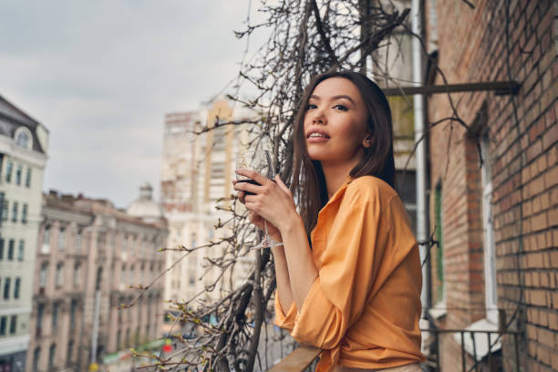 istock Beautiful young woman drinking wine on balcony 1225830119