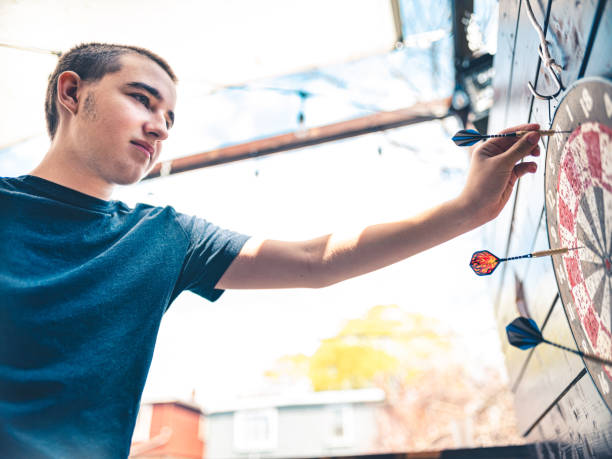 Teenager playing Darts outside