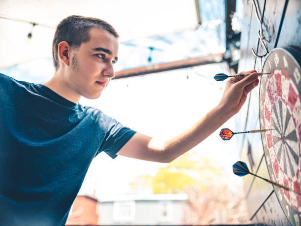 Teenager playing Darts outside