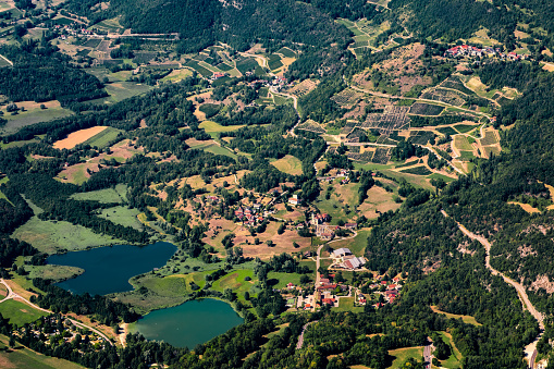 Aerial view of small french village in summer rolling landscape of south Bugey mountains border between Ain and Savoie department