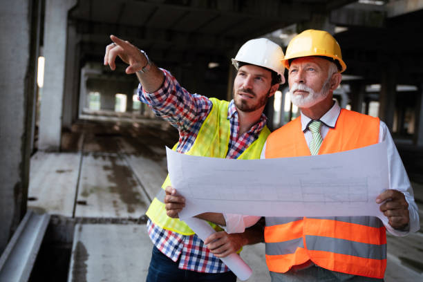 istock Confident team of architects and engineers working together on construction site 1225831968