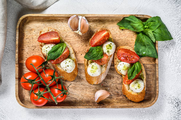 istock sandwiches with tomatoes, mozzarella cheese and basil. italian appetizer, antipasto. gray background. top view 1225832228