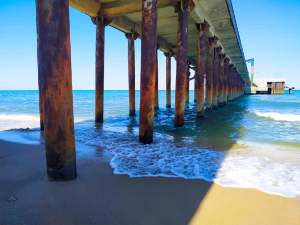 istock View under the dock at the beach. Coming and foamy waves under the dock 1225838802