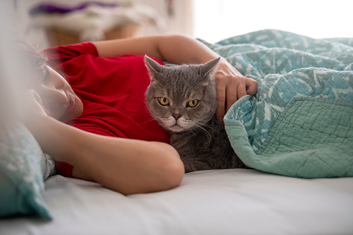 Woman and cat sleeping together.