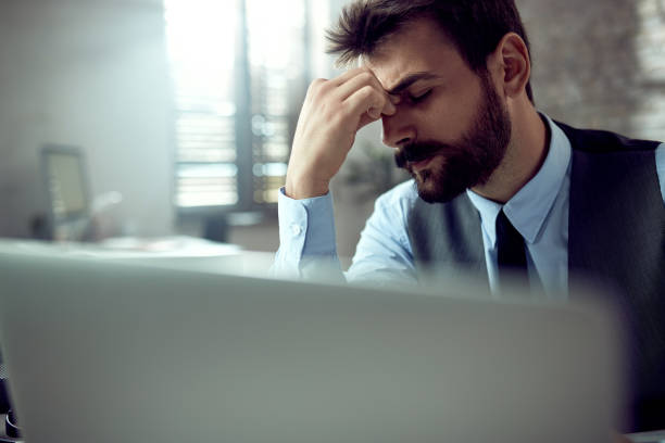 istock Exhausted businessman having a headache after working on laptop in the office. 1225841981