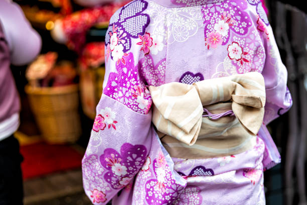 kyoto, japon gros plan de femme méconnaissable dans le kimono violet avec le modèle rose de printemps de fleur de cerisier et ceinture d’obi d’arc attaché - obi sash photos et images de collection