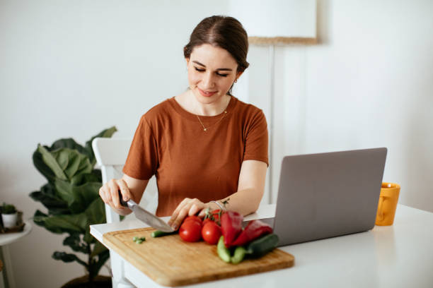 istock Young woman preparing food while working from home 1225850705