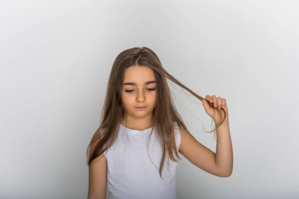 istock Little beautiful sad girl pulls her hair isolated on white background 1225850839