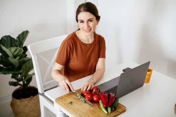 istock Young woman preparing food while working from home 1225851183