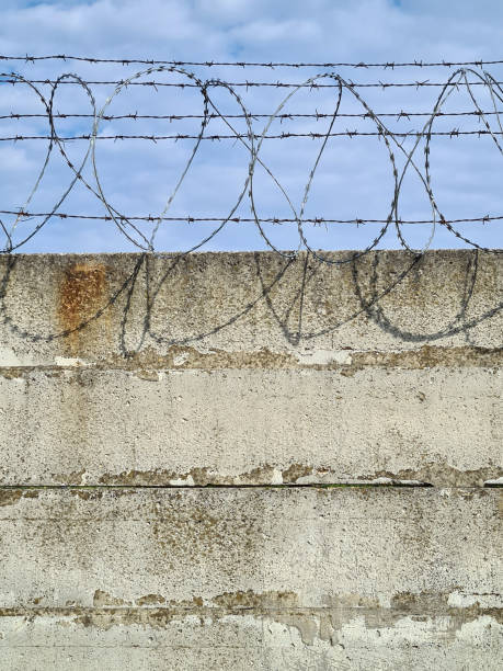 istock Barbed wire on concrete fence 1225852207