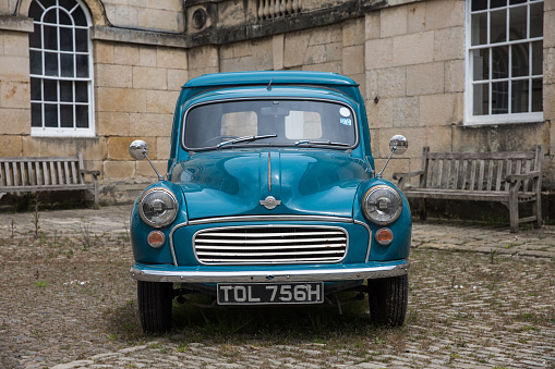 CASTLE HOWARD, YORKSHIRE, UK - MAY 19, 2020.  A blue, vintage Morris Minor Panel Van in old fashioned sourroundings