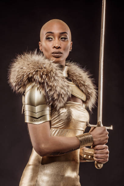 Golden viking inspired warrior female in studio shot Golden viking inspired black warrior female in studio shot period costume stock pictures, royalty-free photos & images