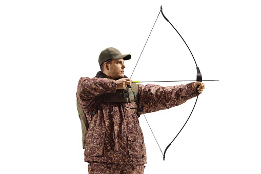 Man hunter in a camuflage uniform aiming with a bow and arrow isolated on white background