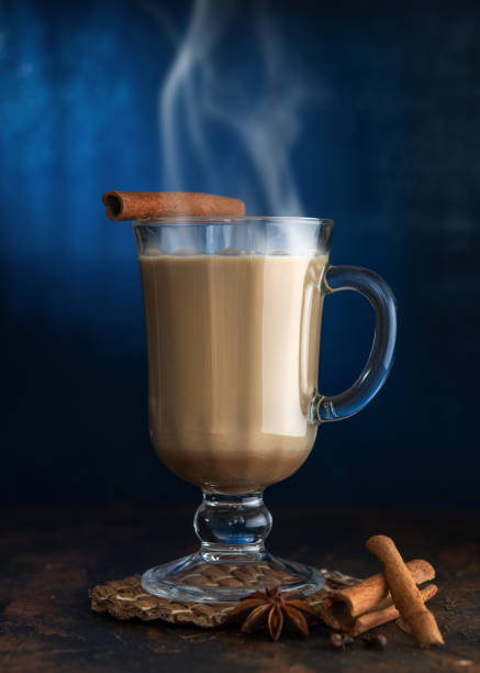 té masala con canela y badian sobre una mesa de barro. un vaso de té masala sobre un fondo azul. - badian fotografías e imágenes de stock