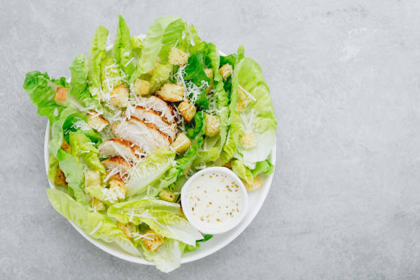 традиционный салат цезарь с курицей, салатом ромэн, гренки и сыром пармезан. - grilled chicken salad salad dressing food стоковые фото и изображения