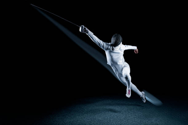 the fencer moves forward with a sword in his hand. sport concept. - fencing sport rivalry sword imagens e fotografias de stock
