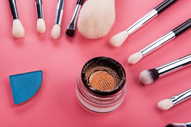 istock Cosmetic palette and face shadow with brushes lies on a pink background 1225863314