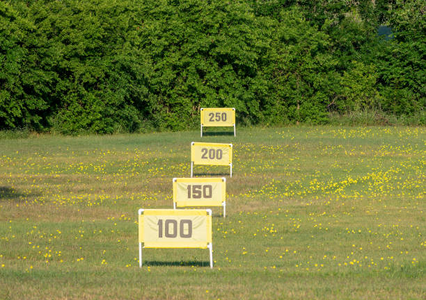 marqueurs de yardage alignés sur une chaîne de conduite de golf - construction yard photos et images de collection