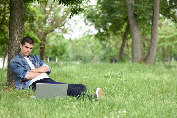 istock Young man working on laptop in the park 1225865977