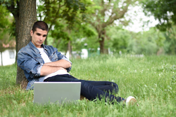 istock Young man working on laptop in the park 1225866017