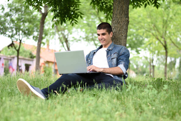 istock Young man working on laptop in the park 1225866033