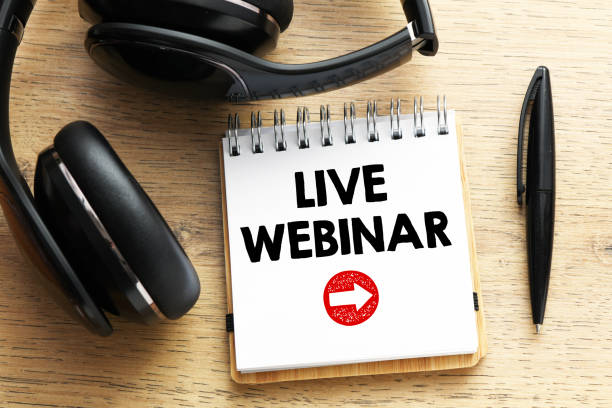 istock LIVE WEBINAR words written in a notebook on a wooden table. 1225872192