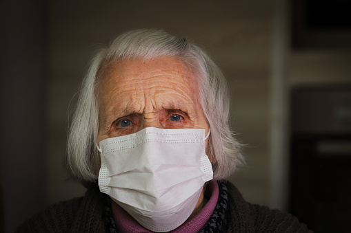 Senior woman with hygienic facial mask. Medical concept.