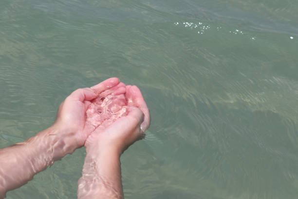 istock Female hands with folded palms in clear water 1225872361