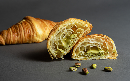Photo of a traditional freshly baked croissant filled with a delicious pistachio cream.