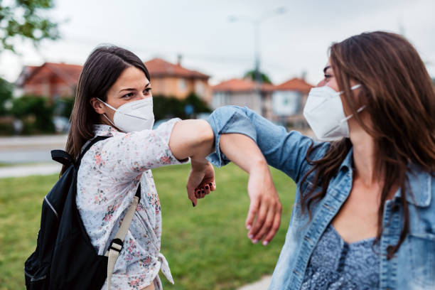 Two friends greeting during pandemic