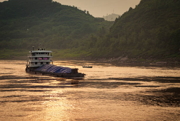 istock Loaded barge sails while sunset reflected by Yangtze River, Chongqing, China. 1225874634