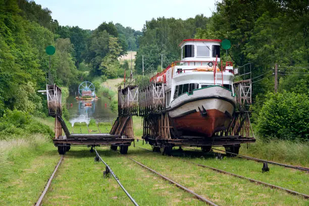 Poland - Elblag canal - Passenger boat crossing inclined plane pulled by railway funcular cable carriage between two channel lakes with blured background