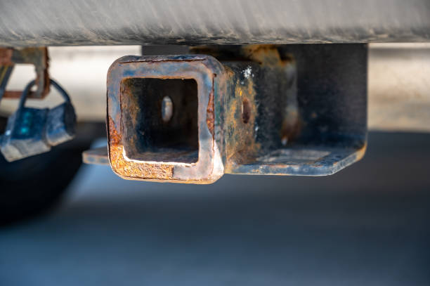 low angle view with subjective shallow focus on vehicle hitch with rust and scratches showing use.