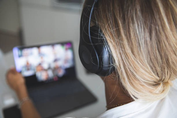 istock Woman using headphones to isolate herself during a business video conference 1225876945