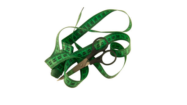 istock Isolated measuring green leather tape and scissors on white background 1225879056
