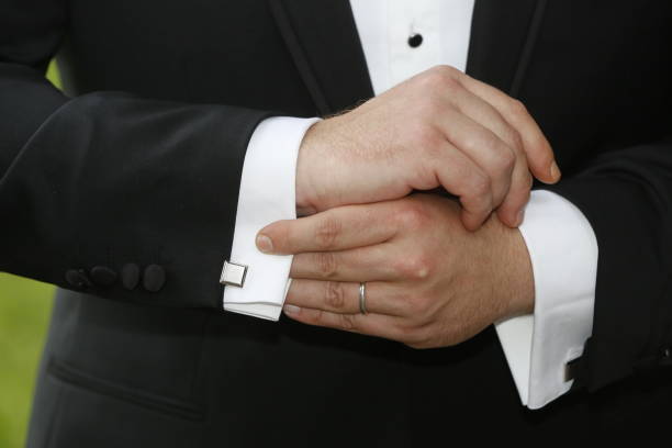 istock of a man in a tux fixing his cufflink 1225879092