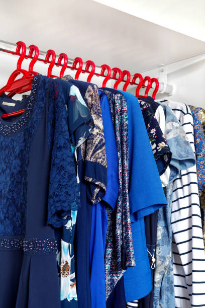 istock Modern closet with row of cloths hanging in white wardrobe. 1225881994