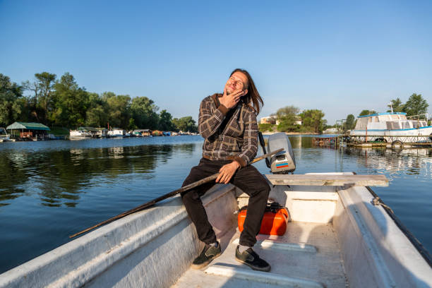 istock Joyful man is rowing over river marina in sunset 1225883189