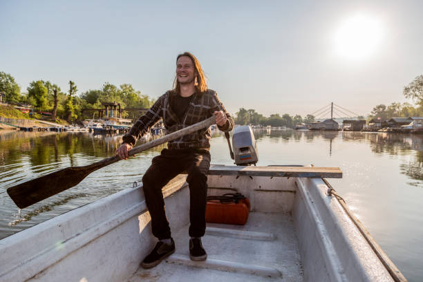 istock Joyful man is rowing over river marina in sunset 1225883216