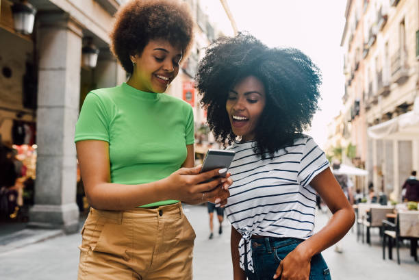 istock Best friends using smartphone on the street 1225884230