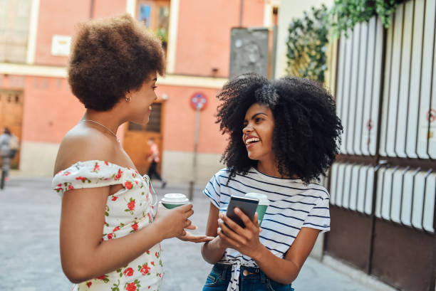 istock Two girls having coffee to go and using smartphone 1225884236